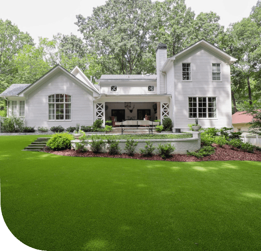 A large white house with green grass on the front lawn.