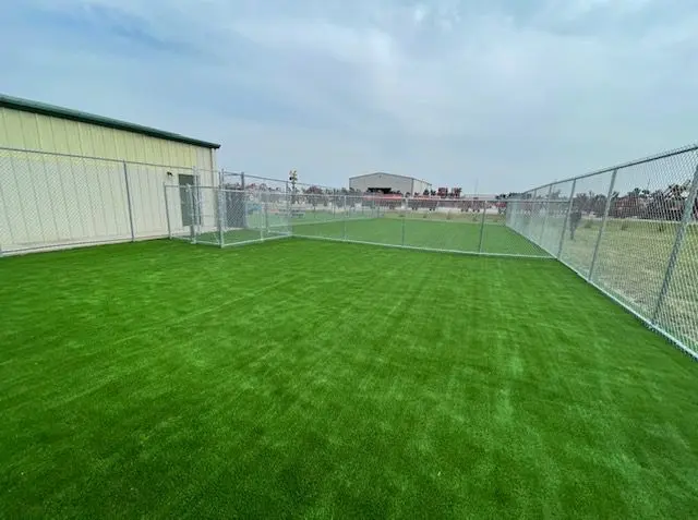 A fenced in area with grass and a fence.