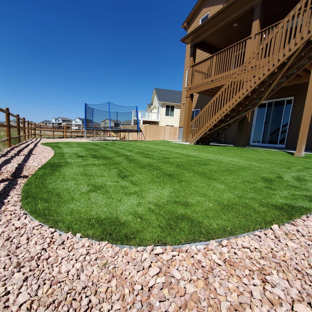 A backyard with a large lawn and a deck.